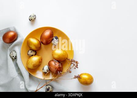 Golden and bronze Easter eggs in a orange plate Stock Photo