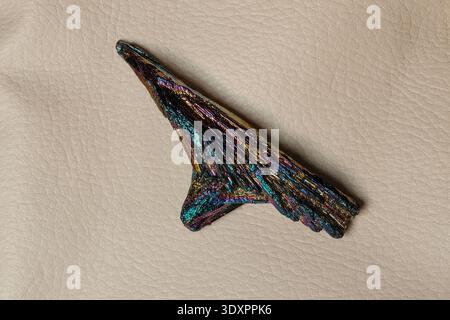 Iridescent Rainbow Kyanite Crystal Cluster on Natural Beige Leather Surface Stock Photo