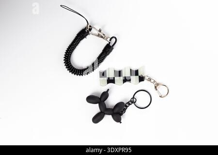 Black and White Checkered Flag and Balloon Dog Keychains on White Background Stock Photo