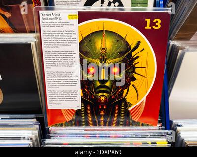 Manchester, UK - February 28, 2026: Colorful sci fi robot illustration on a Red Laser EP 13 vinyl sleeve displayed in a record shop rack. Stock Photo