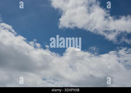 White and grey clouds scattered across a bright blue sky Stock Photo