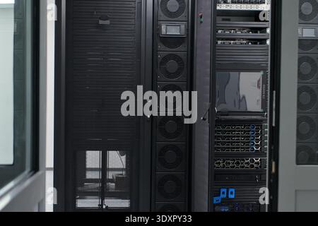 Modern server racks inside a secure data center room showing network equipment and storage infrastructure Stock Photo