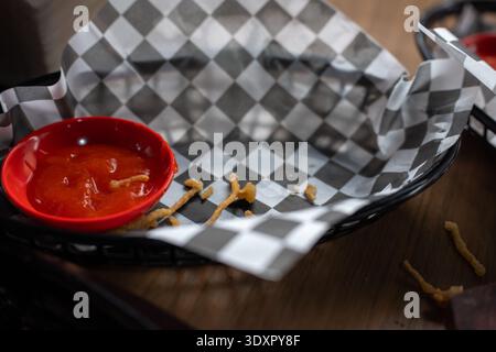 Empty food basket with checkered paper red sauce and fried crumbs Stock Photo