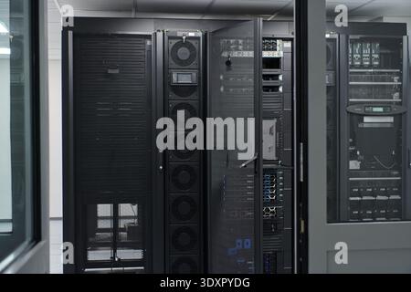 Data center server racks and network equipment in a secure IT room with cooling and cabling Stock Photo
