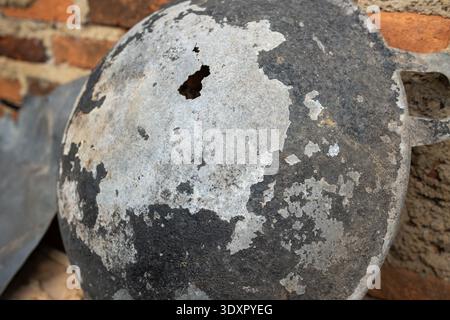 Weathered metal pan bottom with peeling black soot and a hole Stock Photo