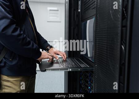 Data center technician working on a rack server using a slide-out laptop console Stock Photo