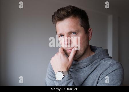 Close up portrait of a thoughtful middle aged man looking into the camera with a pensive expression Stock Photo