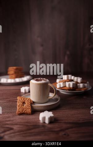 cozy scene with a mug of frothy hot chocolate topped with chocolate shavings, surrounded by intricately designed cookies and decorative sugar cubes on Stock Photo