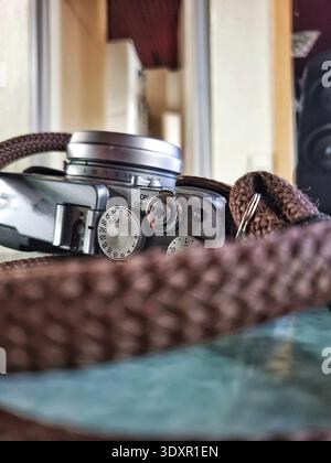 Old Camera With Nostalgic Ambiance. Classic Photographic Device With Leather Strap In Soft Focus Stock Photo