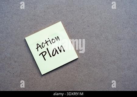 Top view of a yellow note with the text 'Action Plan' on a rustic desk. Represents strategy, goal setting, and professional organization. Stock Photo