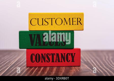 Customer, Values, and Constancy text on colorful wooden blocks. Business concept for brand loyalty, customer service excellence, and marketing strateg Stock Photo