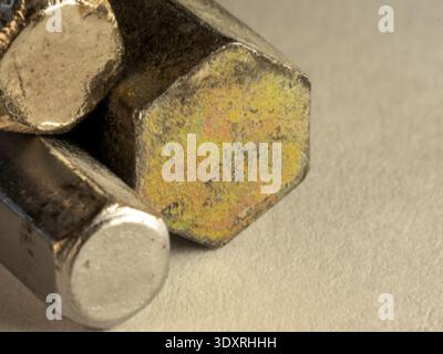 Weathered metal bolt rests beside its hexagonal head. Surface shows rust and wear, indicating heavy use. Soft lighting highlights textures and subtle Stock Photo