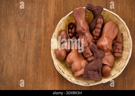 Basket filled with assorted chocolate bunnies and easter eggs Stock Photo