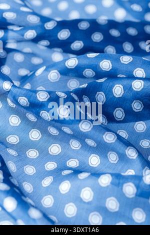Abstract blue natural silk background. Silk fabric with polka dots pattern closeup. Stock Photo
