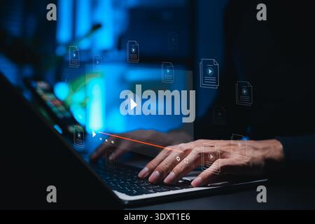 Multimedia entertainment concept of hands typing on laptop with virtual video player and file icons for movie streaming, online education, content Stock Photo