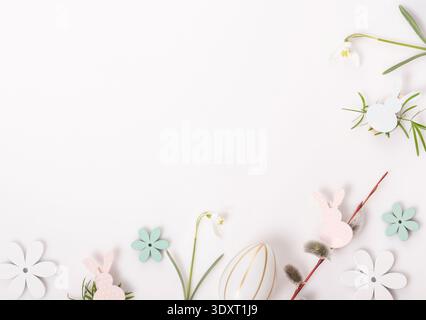 Minimal Easter background with snowdrop flowers, paper bunnies and egg decoration, spring holiday flat lay with copy space Stock Photo