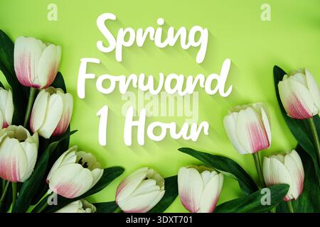 Spring Forward 1 Hour Daylight Savings Time message with bunch of flowers on green background Stock Photo