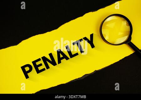 Penalty text on yellow with black paper torn ripped and magnifying glass Stock Photo