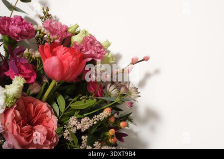 Floral bouquet with pink roses, tulips, and hypericum berries on a white background. Copyspace. Stock Photo
