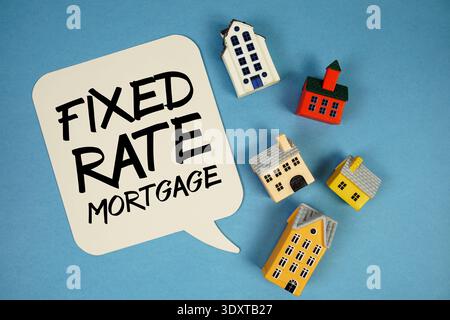 Fixed-Rate Mortgage text with house models on blue background Stock Photo