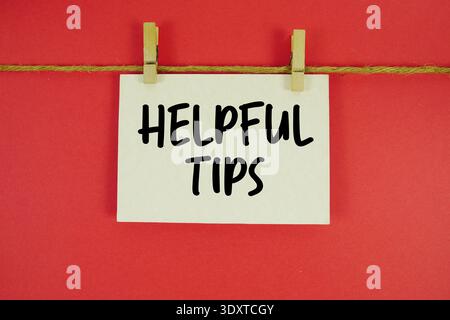 Helpful Tips paper notes hanging on the rope with clothespins Stock Photo
