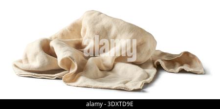 dirty crumpled beige fabric cloth isolated white background, textured knit material with visible stains and irregular folds, closeup side view Stock Photo