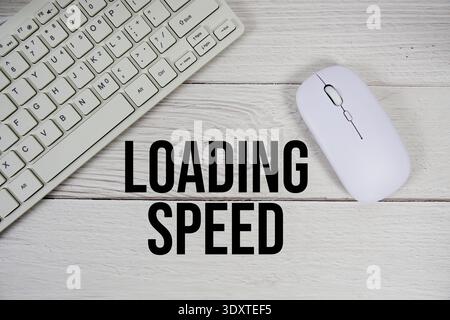 Loading Speed text with keyboard and wireless mouse on wooden background Stock Photo