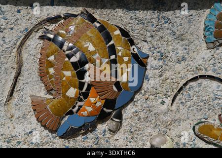 Vibrant mosaic fish artwork in green, turquoise, orange, and pink tiles embedded in the stone pavement of Nice's old town street.Nice,France Stock Photo