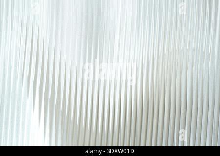 A soft white fabric with subtle folds and shadows creating a gentle and flowing abstract pattern effect Stock Photo