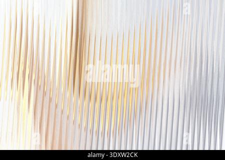 A blurry close up of a light colored object with a tan or beige stripe on a white or light background Stock Photo