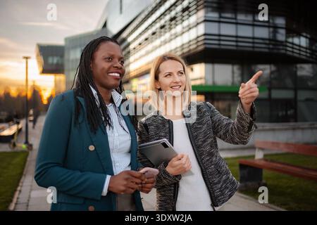 Diverse businesswomen discussing outdoor project Stock Photo