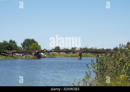 Low road bridge over calm river with navigation signs in Poland Stock Photo