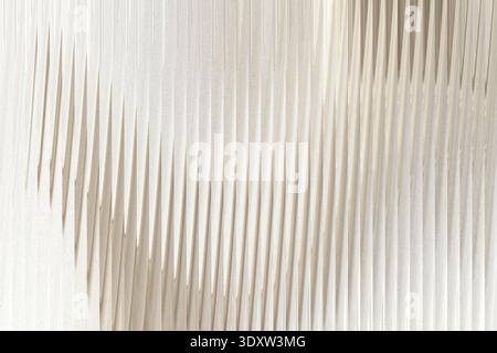 A blurry abstract image showing soft white and beige tones with subtle light and shadow gradients present Stock Photo