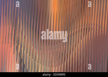 A blurry abstract painting featuring shades of brown orange and purple with vertical brushstrokes effect Stock Photo