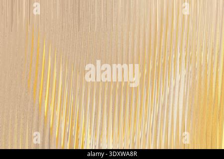 A textured beige background features soft, blurred shadows creating an abstract and subtly patterned surface Stock Photo