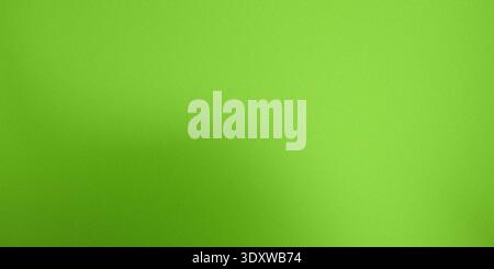 A close-up, abstract background featuring a rich, vibrant lime green color with a fine, uniform grainy texture or noise overlay, creating a subtle vis Stock Photo