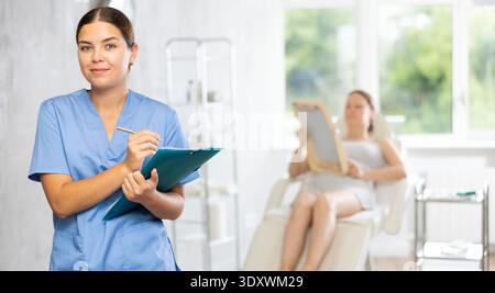 Young female doctor making notes in medical room Stock Photo