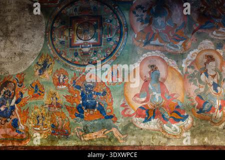Intricate Tibetan Buddhist mural featuring a central mandala and various deities painted on an interior wall of Thiksey Gompa. Stock Photo