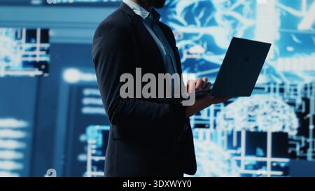 Young entrepreneur reviewing predictive analytics and machine learning algorithms. The digital interface reflects innovation, coding, AI ethics and platforms transformation. Camera A. Stock Photo