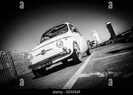 black & white Low angle view of a classic vintage 1960s white Fiat 500 convertible parked on asphalt in dramatic monochrome wide angle north shields Stock Photo