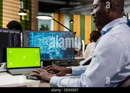 Chroma key laptop used by developer in AI tech company workplace to conduct code reviews. IT specialist using mockup notebook at office desk to design and implement machine learning algorithms Stock Photo