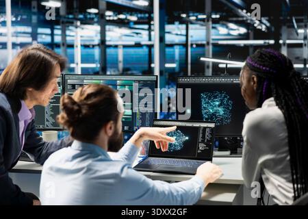 Team of programmers doing brainstorming in data center, optimizing equipment for AI tasks, increasing workloads. Coworkers cooperating in server hub, automating system diagnostics using deep learning Stock Photo