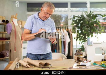 Man tailor makes pattern using tablet Stock Photo