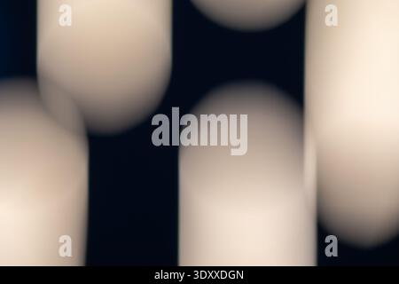 soft blurred cream cylinders on a deep black background, creating an elegant minimalist abstract composition with smooth bokeh gradients and sophistic Stock Photo