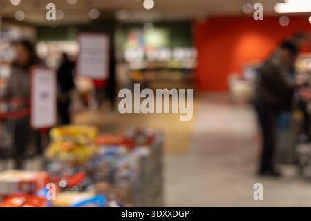 blurred interior of a modern supermarket with shoppers, bokeh lighting, and colorful grocery displays, perfect for retail backgrounds and consumerism Stock Photo