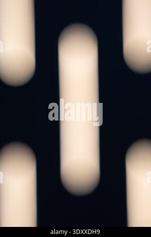 abstract minimalist composition of glowing vertical light bars on a dark background featuring soft bokeh effect and smooth blur for modern art Stock Photo