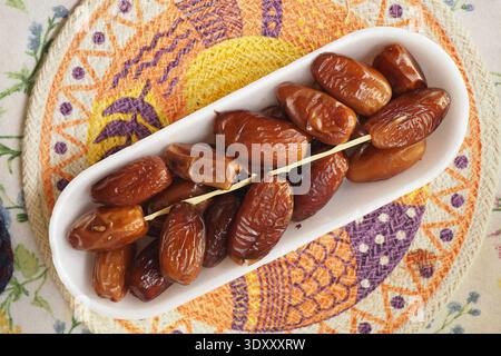 Fresh dates served on a plate during a meal Stock Photo