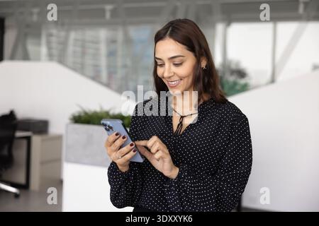 Positive young business company worker woman typing on mobile phone Stock Photo