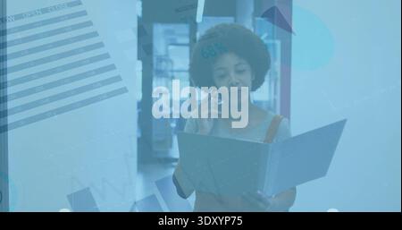 Holding file, woman in overall straps talking on phone in office hallway, shelves doorway charts Stock Photo