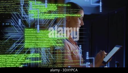 Holding tablet, woman in pink jacket tapping stylus in server room with green code, copy space Stock Photo